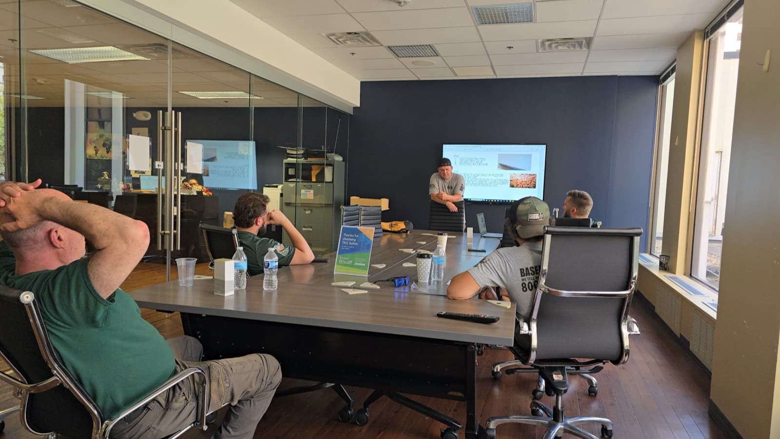Basement Gurus crew and estimators around the table at a training session in the Lancaster office.
