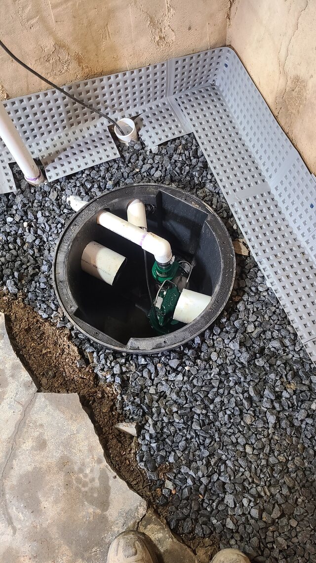 Sump pump installed in a basin tied into a perimeter drain, with clean stone and a dimpled wall membrane, in a Columbia, PA basement